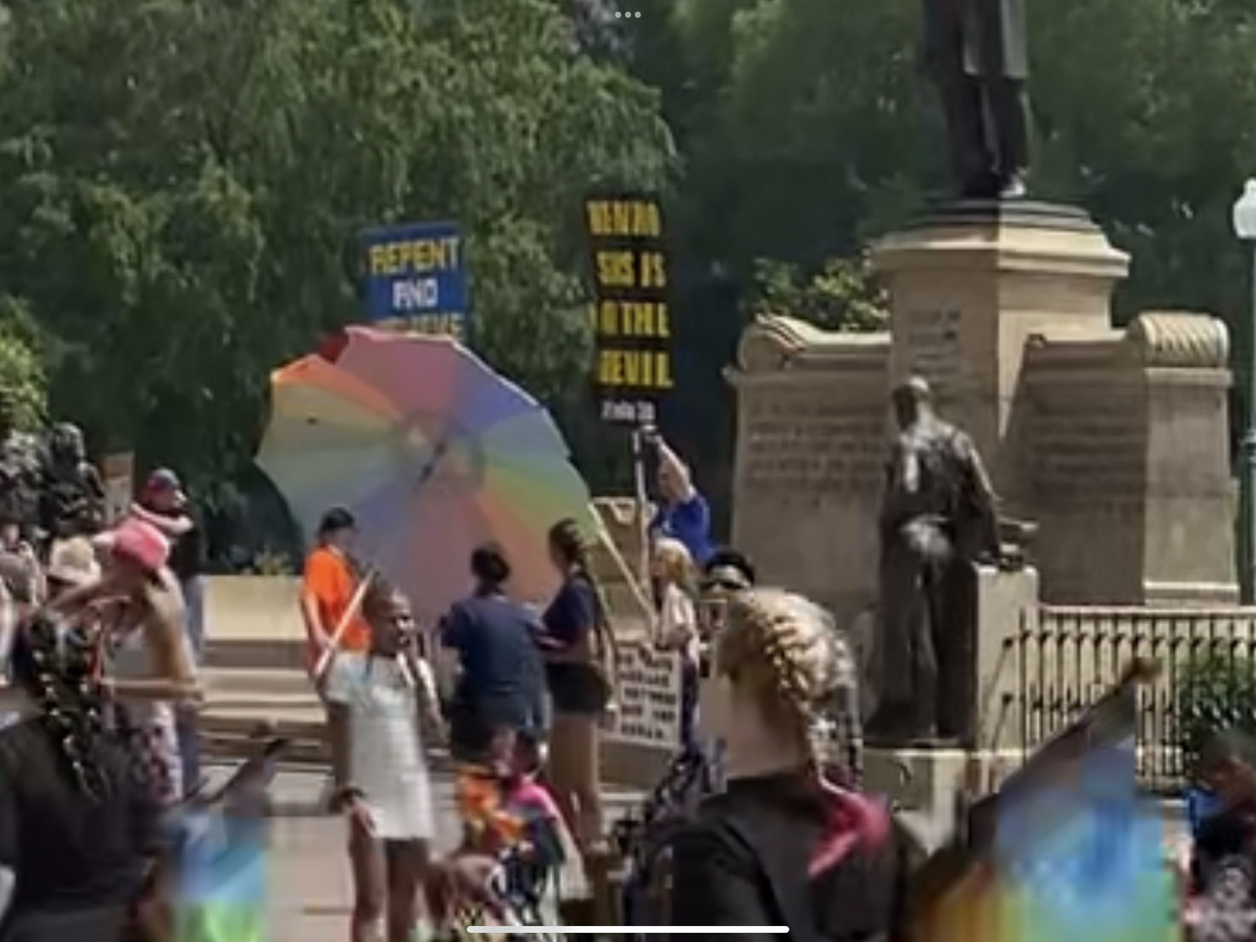 A photo of street preachers at a pride parade with big signs protesting the event